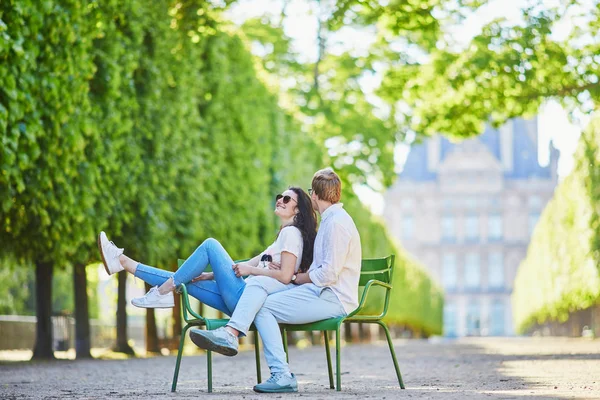 Счастливая романтическая пара в Париже, сидящая на традиционных зеленых металлических стульях в саду Тюильри — стоковое фото