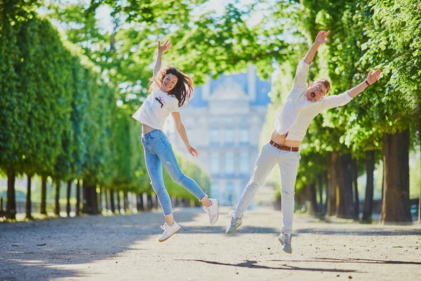 Счастливая романтическая пара в Париже, прыжки в саду Тюильри — стоковое фото