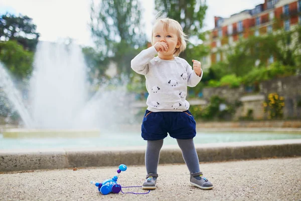 パンを食べる公園で屋外で愛らしい小さな女の子 — ストック写真