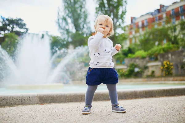 Entzückendes kleines Mädchen im Park beim Brotessen — Stockfoto