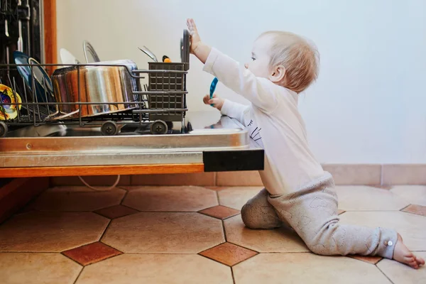 Pequeño niño ayudando a descargar lavavajillas — Foto de Stock