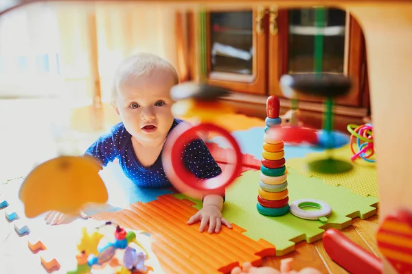 Baby flicka leker med leksaker på golvet — Stockfoto