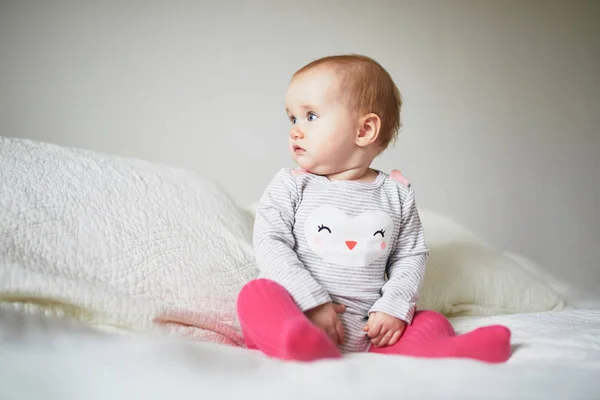 Baby meisje zittend op bed — Stockfoto