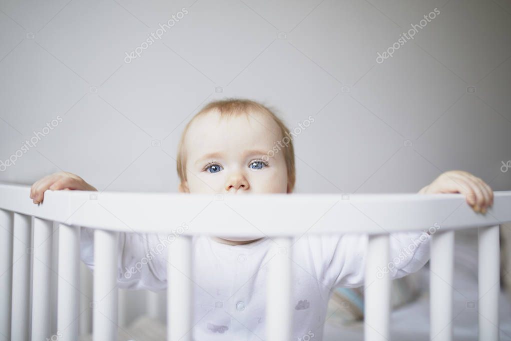 Adorable baby girl in co-sleeper crib