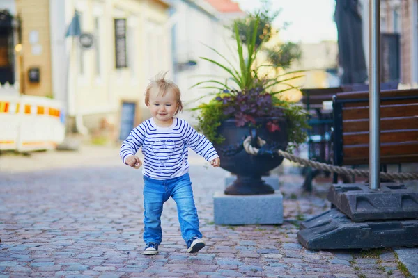 Gelukkig lachende peuter wandelen in de straat van de Finse stad Porvoo — Stockfoto
