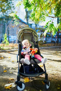 parlak şık kıyafetler bir sonbahar gününde açık havada oturan kız