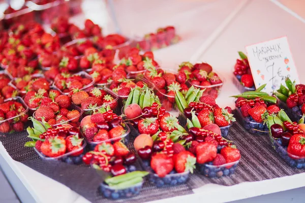 Fresas frescas y guisantes verdes a la venta en el mercado local de alimentos — Foto de Stock