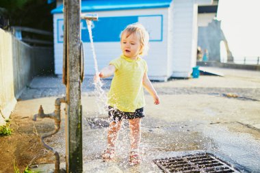 Açık havada su musluk ile oynarken sevimli Toddler kız