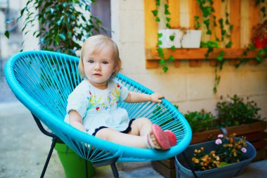 Fantezi sandalyede oturan çok güzel Toddler kız