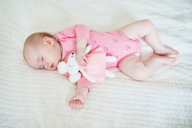 Bebek en sevdiği fare oyuncağıyla kestiriyor.