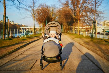 Sevimli mutlu küçük kız açık havada puset oturan