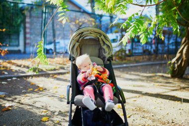 parlak şık kıyafetler bir sonbahar gününde açık havada oturan kız