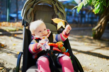 parlak şık kıyafetler bir sonbahar gününde açık havada oturan kız