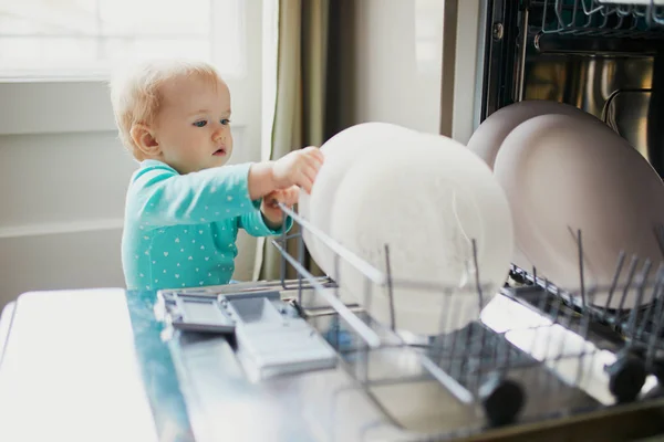 Pequeño niño ayudando a descargar lavavajillas —  Fotos de Stock