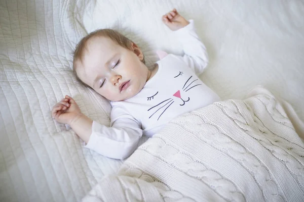 Adorável bebê menina dormindo no berço sob cobertor de malha — Fotografia de Stock