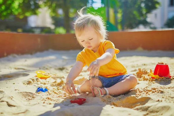 Mała dziewczynka zabawy na placu zabaw w piaskownica — Zdjęcie stockowe