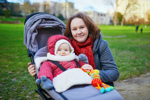 ベビーカーで彼女の小さな女の赤ちゃんと女性。公園を歩く母 — ストック写真