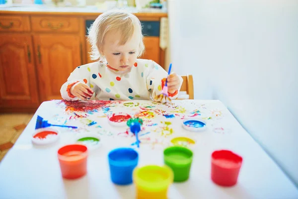 Kleines Mädchen malt zu Hause mit den Fingern — Stockfoto