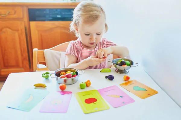 Adorável menina brincando com frutas e legumes de brinquedo — Fotografia de Stock
