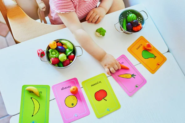 Flicka leker med leksaks frukter och grönsaker — Stockfoto