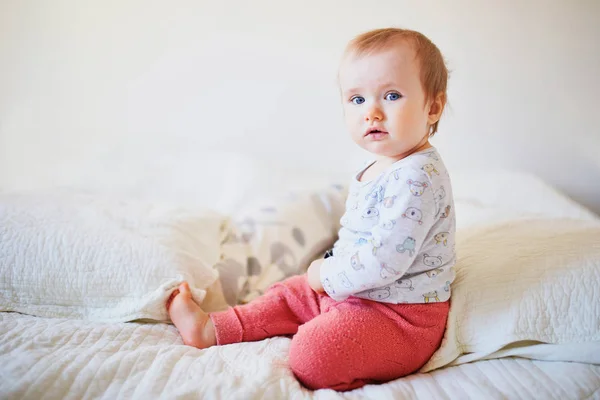Baby Mädchen sitzt auf dem Bett — Stockfoto