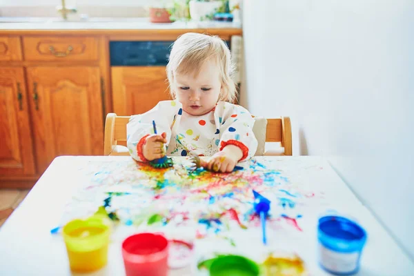 Kleines Mädchen malt zu Hause mit den Fingern — Stockfoto