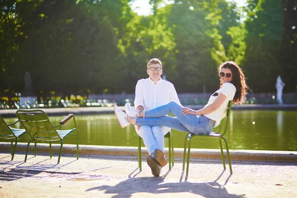 Šťastný romantický pár v Paříži, který sedí na tradičních zelených kovových křeslech v Tuileriích zahrádce — Stock fotografie