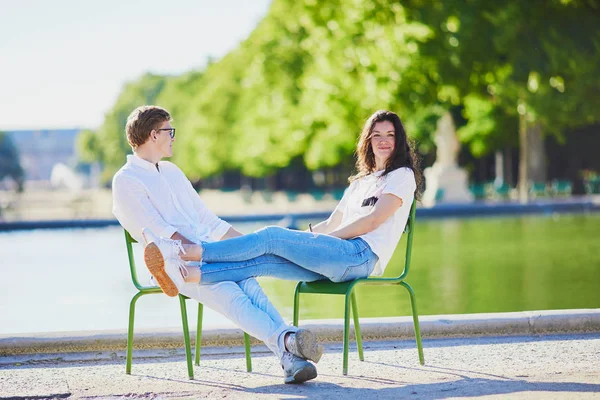 Χαρούμενο ρομαντικό ζευγάρι στο Παρίσι, καθισμένος σε παραδοσιακές πράσινες μεταλλικές καρέκλες στον κήπο του Κεραμεικού — Φωτογραφία Αρχείου