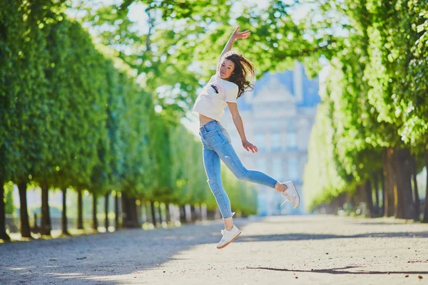 快乐的年轻女孩在巴黎，在杜伊勒里花园跳跃 — 图库照片