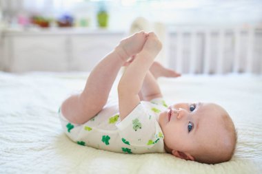 Sırtüstü uzanmış tatlı bir kız bebek.