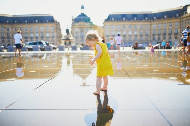 Bordeaux eğlenceli ünlü açık su çeşmesi (Miroir d'eau) sahip yürümeye başlayan kız