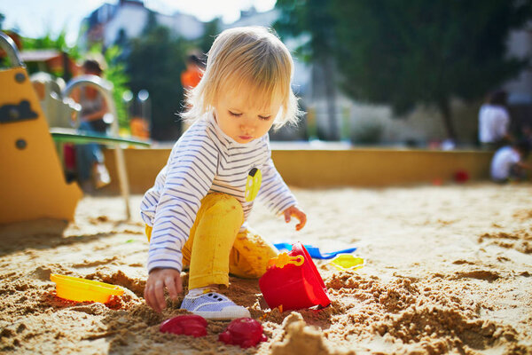girl on playground in sandpit