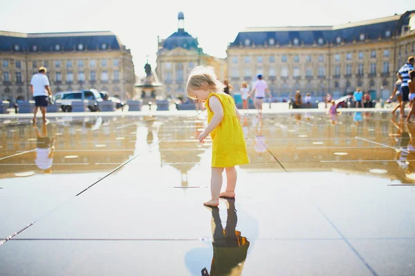 Kleinkind-Mädchen mit Spaß berühmten Outdoor-Brunnen (miroir d 'eau) in Bordeaux — Stockfoto