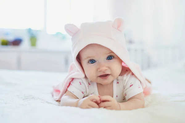 Dítě dívka relaxační v ložnici v růžovém oblečení nebo ručník s ušima — Stock fotografie