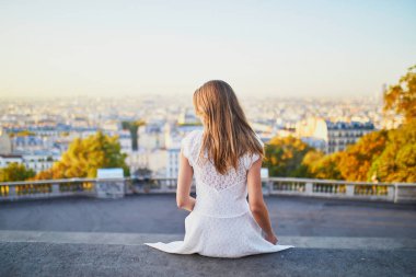 woman in white dress walking on famous Montmartre hill in Paris