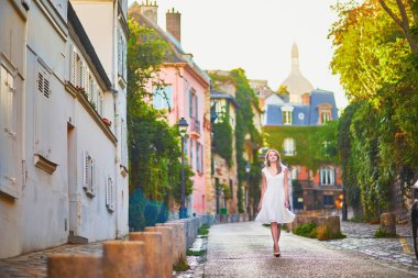 woman in white dress walking on famous Montmartre hill in Paris