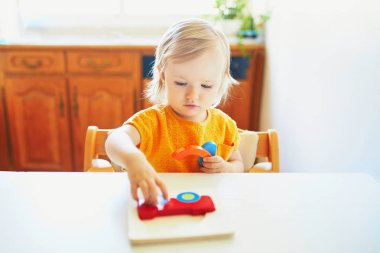 Sevimli yürümeye başlayan kız ahşap bulmaca yapıyor