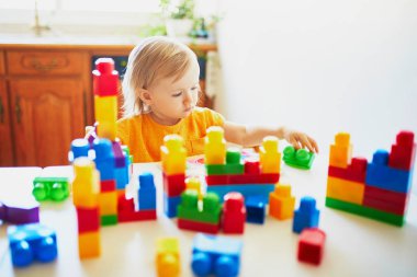 Küçük kız renkli plastik yapı blokları ile oynuyor