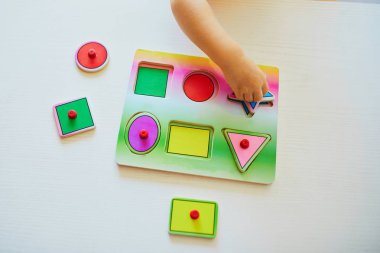 Sevimli yürümeye başlayan kız ahşap bulmaca yapıyor