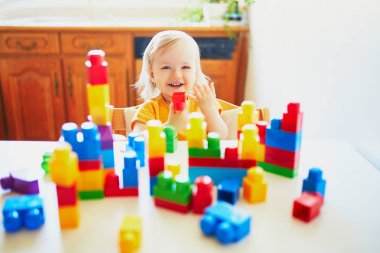 Küçük kız renkli plastik yapı blokları ile oynuyor
