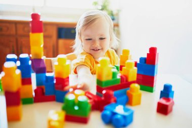 Küçük kız renkli plastik yapı blokları ile oynuyor