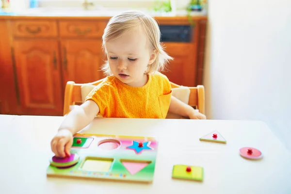 Adorable toddler girl doing wooden puzzle — Stock Photo, Image