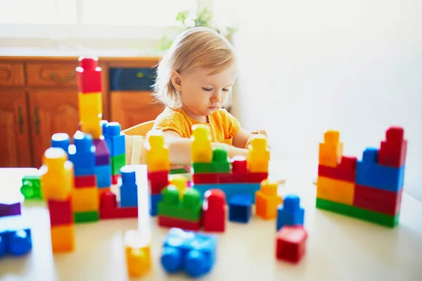 小女孩玩五颜六色的塑料建筑块 — 图库照片