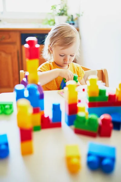 Девочка играет с красочными пластиковыми блоками — стоковое фото
