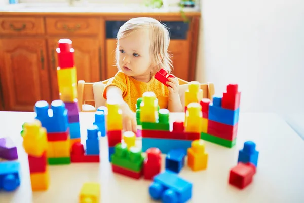 Niña jugando con bloques de construcción de plástico de colores — Foto de Stock