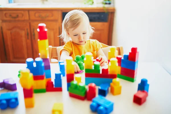 Niña jugando con bloques de construcción de plástico de colores — Foto de Stock