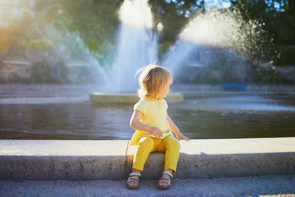 Menina adorável criança olhando para fonte no parque da cidade em um dia de verão — Fotografia de Stock