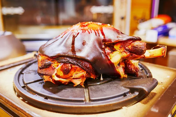 Large grilled pork leg on brazier on traditional Christmas market — Stock Photo, Image