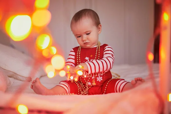 Joyeux bébé fille en pyjama jouant avec les décorations de nouvel an arbre — Photo