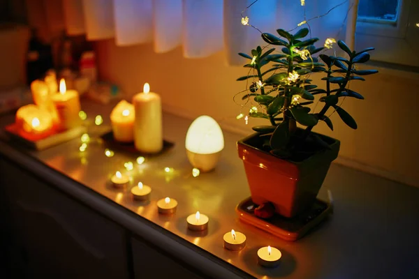 Cozy decoration of window sill with many candles and light garlands — Stock Photo, Image